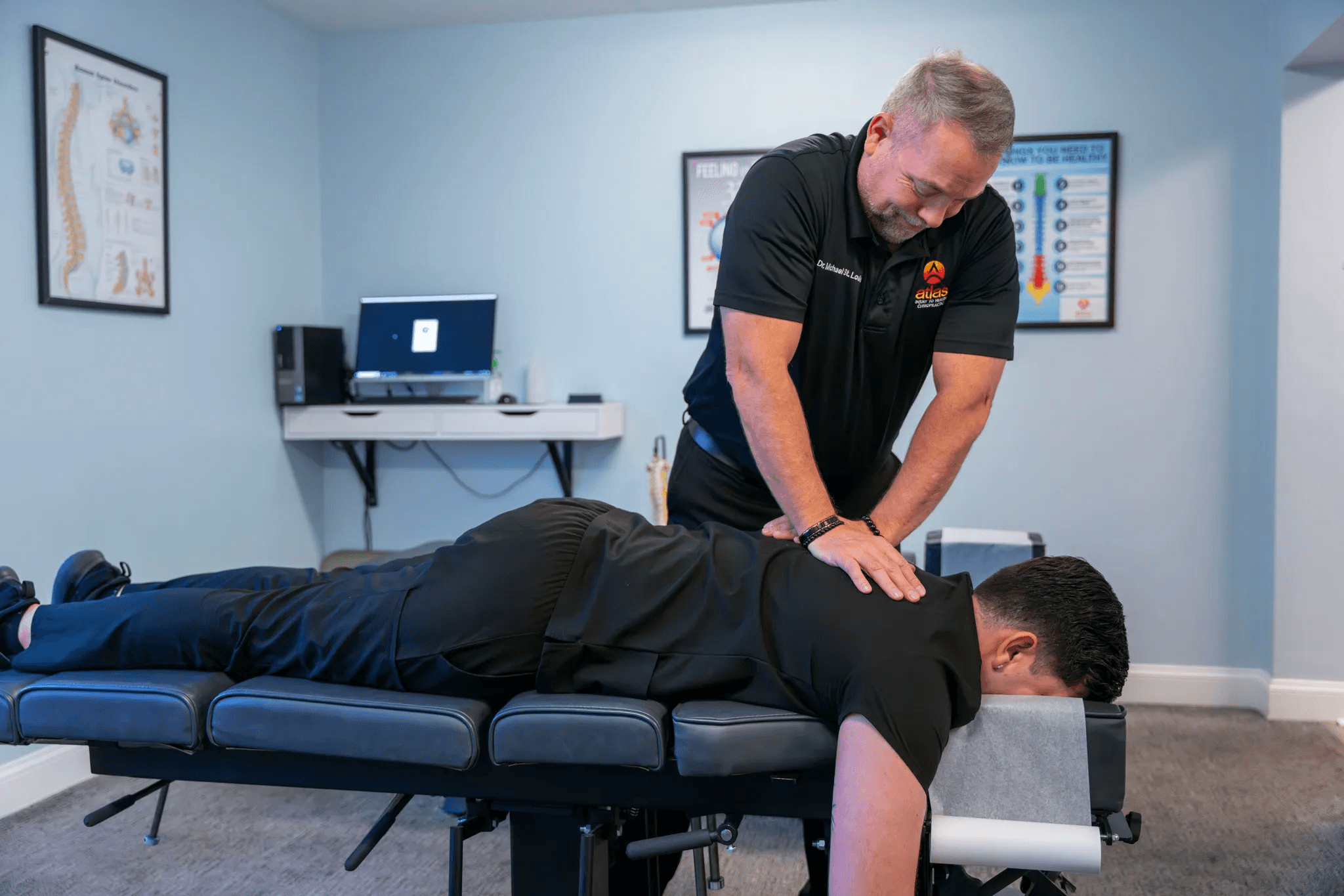 Clinician at Atlas Injury to Health applies focused upper cervical care to a patient lying prone on a treatment table